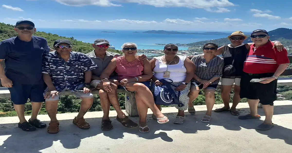 Group of adults posing for a vacation photo.
