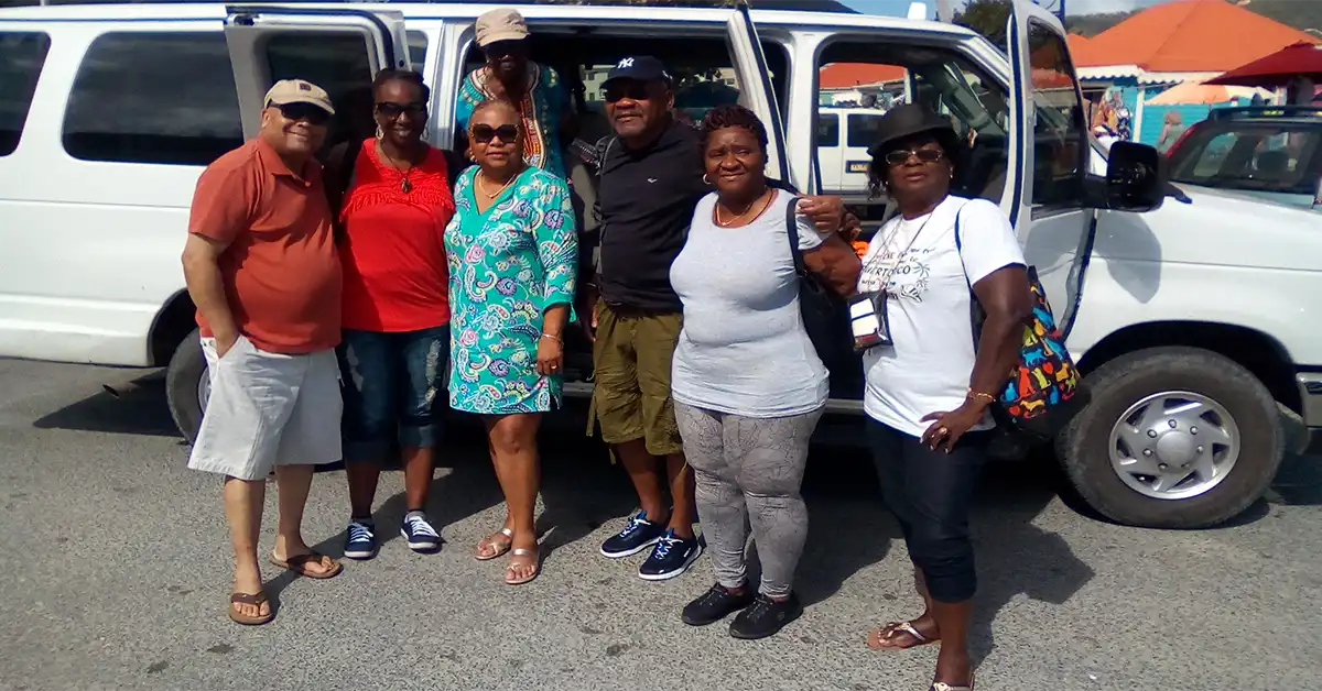 Guests standing beside a Yo Yo Mr. Taxi van in Tortola.