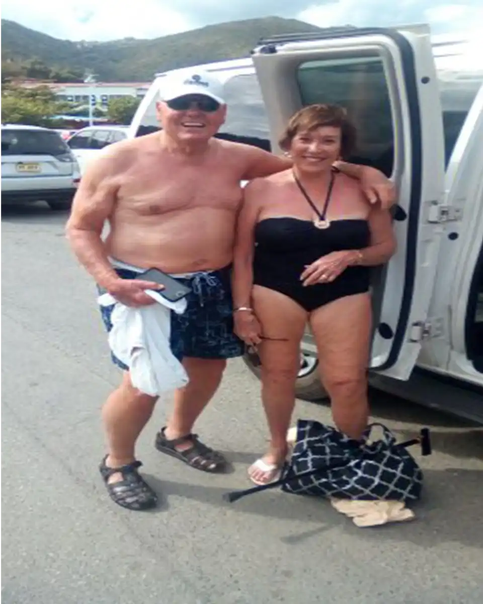 Older couple taking a photo at a scenic stop.